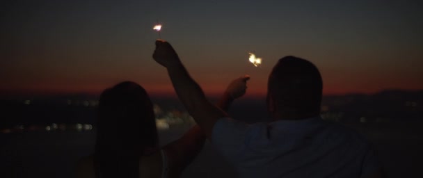 Silueta Pareja Joven Celebrando Mientras Sostiene Los Destellos Atardecer Con — Vídeo de stock