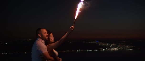 Young Couple Hugging Smiling While Holding Firework Hill Night Bokeh — Stock Video