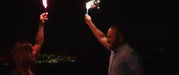 Jovem Casal Pulando Divertindo Desfrutar Comemorar Enquanto Segurando Fogos Artifício — Vídeo de Stock