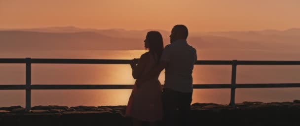 Unga Par Njuter Att Titta Solnedgången Ovanför Den Vackra Sjön — Stockvideo