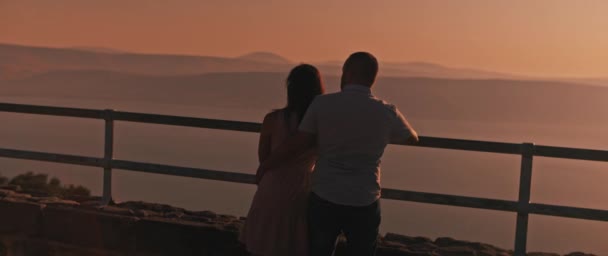 Unga Par Njuter Att Titta Solnedgången Ovanför Den Vackra Sjön — Stockvideo