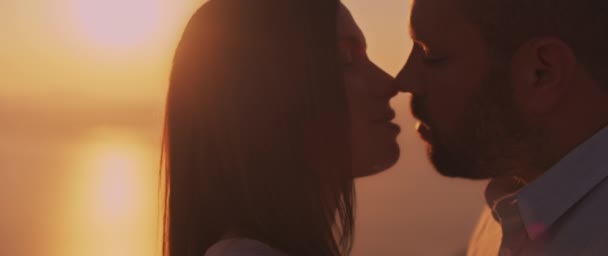 日没の愛を持ってお互いを見ている若いカップルの閉じる その背後に美しい太陽のフレアと スローモーション — ストック動画