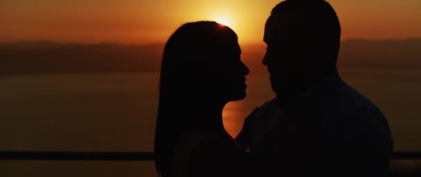 日没時に抱擁する若いカップルの終わりに ロマンチックな夜を一緒に過ごす スローモーション — ストック動画