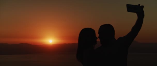 Silhouette Eines Jungen Paares Das Bei Sonnenuntergang Ein Selfie Beim — Stockvideo