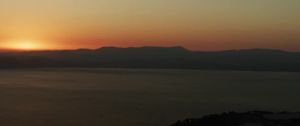 Beau paysage avec coucher de soleil sur le grand lac et les montagnes. Panoramique à gauche. 