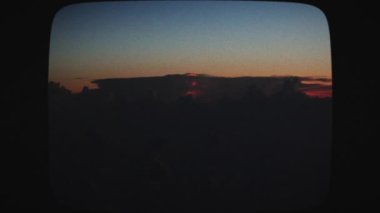 Gün batımında bulutlara düşen yıldırımların uçak görüntüsü. Şimşek ve gök gürültüsü çakan fırtınalı bir gökyüzü. Akşam fırtınası bulutları. Klasik Film Görünümü.