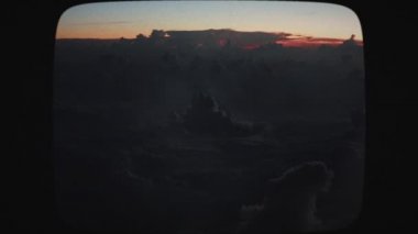 Gün batımında bulutlara düşen yıldırımların uçak görüntüsü. Şimşek ve gök gürültüsü çakan fırtınalı bir gökyüzü. Akşam fırtınası bulutları. Klasik Film Görünümü.