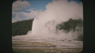 Old Faithful Gayzer püskürmesi, Yellowstone Ulusal Parkı, Wyoming, ABD. Klasik Film Görünümü. 
