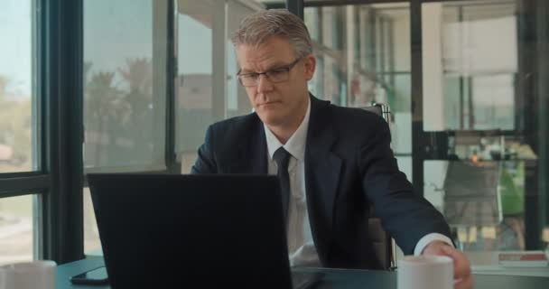 Biznesmen Formalnym Stroju Okularach Pijący Drinka Podczas Pracy Laptopie Biurze — Wideo stockowe