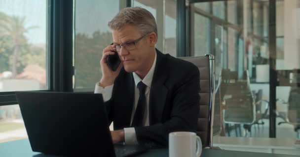 Hombre Negocios Hablando Por Teléfono Mientras Trabajaba Portátil Oficina Seguimiento — Vídeo de stock