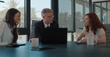 Bir grup iş arkadaşı yeni bir proje hakkında konuşuyor, bir iş toplantısı sırasında fikirlerini paylaşıyorlar. Yavaş çekim.