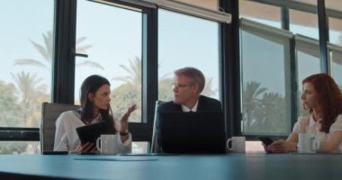 Bir grup insan iş yerinde bilgisayar kullanarak bir projeyi tartışıyor. İş toplantısı, birlikte çalışmak, fikir paylaşımı. Yavaş çekim.
