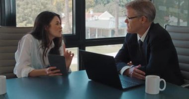 Genç bir iş kadını bir iş görüşmesi sırasında proje fikirlerini bir meslektaşıyla paylaşıyor. Yavaş çekim.