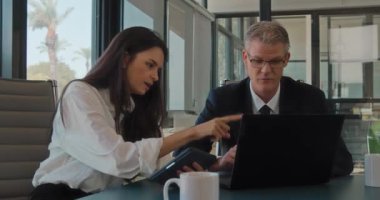 Bilgisayar kullanarak yeni bir projeyi tartışan iki meslektaşımızı kapatıyoruz. İş toplantısı, birlikte çalışmak, fikir paylaşımı. Yavaş çekim.