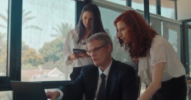 Üç kişilik yaratıcı iş ekibi yeni bir projeyi tartışıyor. İş toplantısı, birlikte çalışmak, fikir paylaşımı. Yavaş çekim.