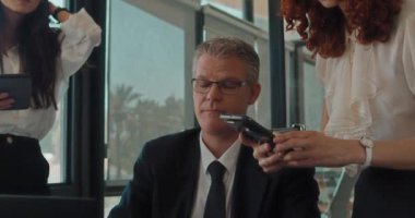 İş görüşmesi sırasında bilgisayardan bir şeyin fotoğrafını çeken bir iş kadını. Yavaş çekim.