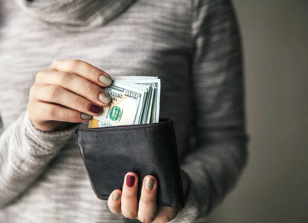 Nelle mani delle donne c'è il portafoglio in pelle con una mazzetta di cento dollari. Offerta di lavoro. Bella manicure — Foto Stock