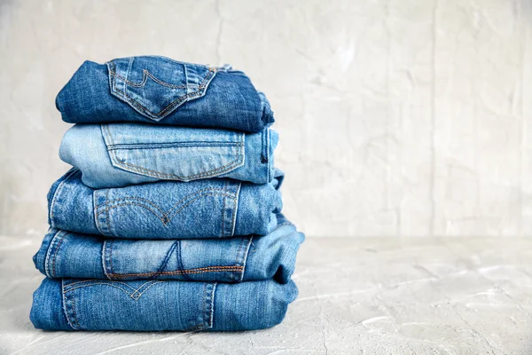 Stack of blue jeans on a gray background — Stock Photo, Image