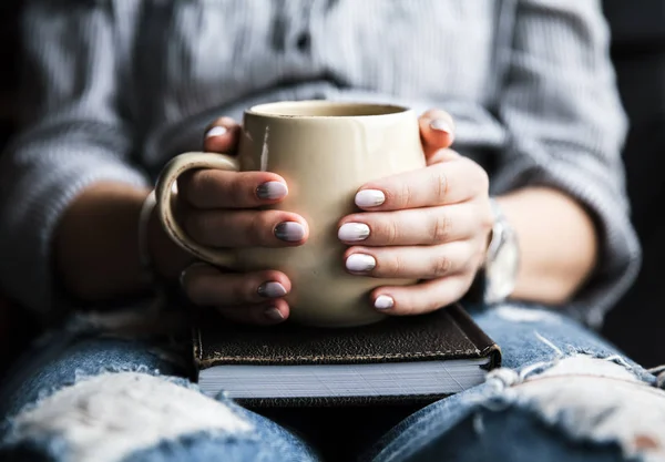 Mladá dívka s krásnou manikúru drží knihu s šálkem kávy. Módní styl — Stock fotografie