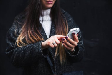 Cep telefonu siyah bir arka plan üzerinde mutlu güzel kadın sahiptir