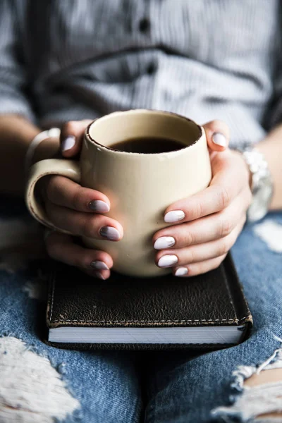 Mladá dívka s krásnou manikúru drží knihu s šálkem kávy. Módní styl — Stock fotografie