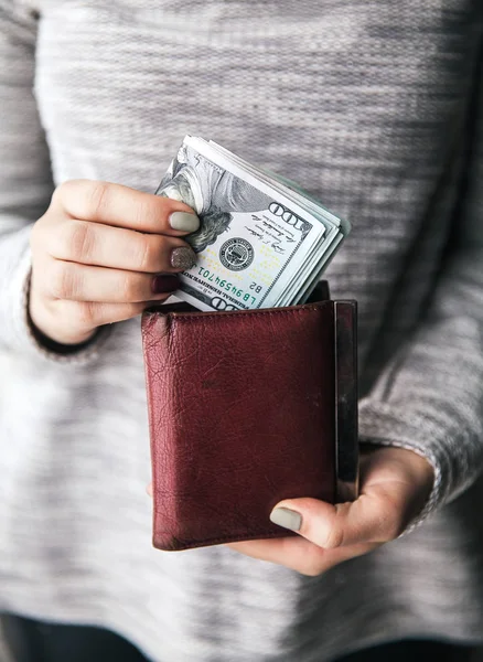 V rukou žen je hnědá kožená peněženka s svazek sto dolarů. Obchodní nabídka. Krásnou manikúru — Stock fotografie