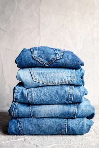 Stack of blue jeans on a gray background — Stock Photo, Image