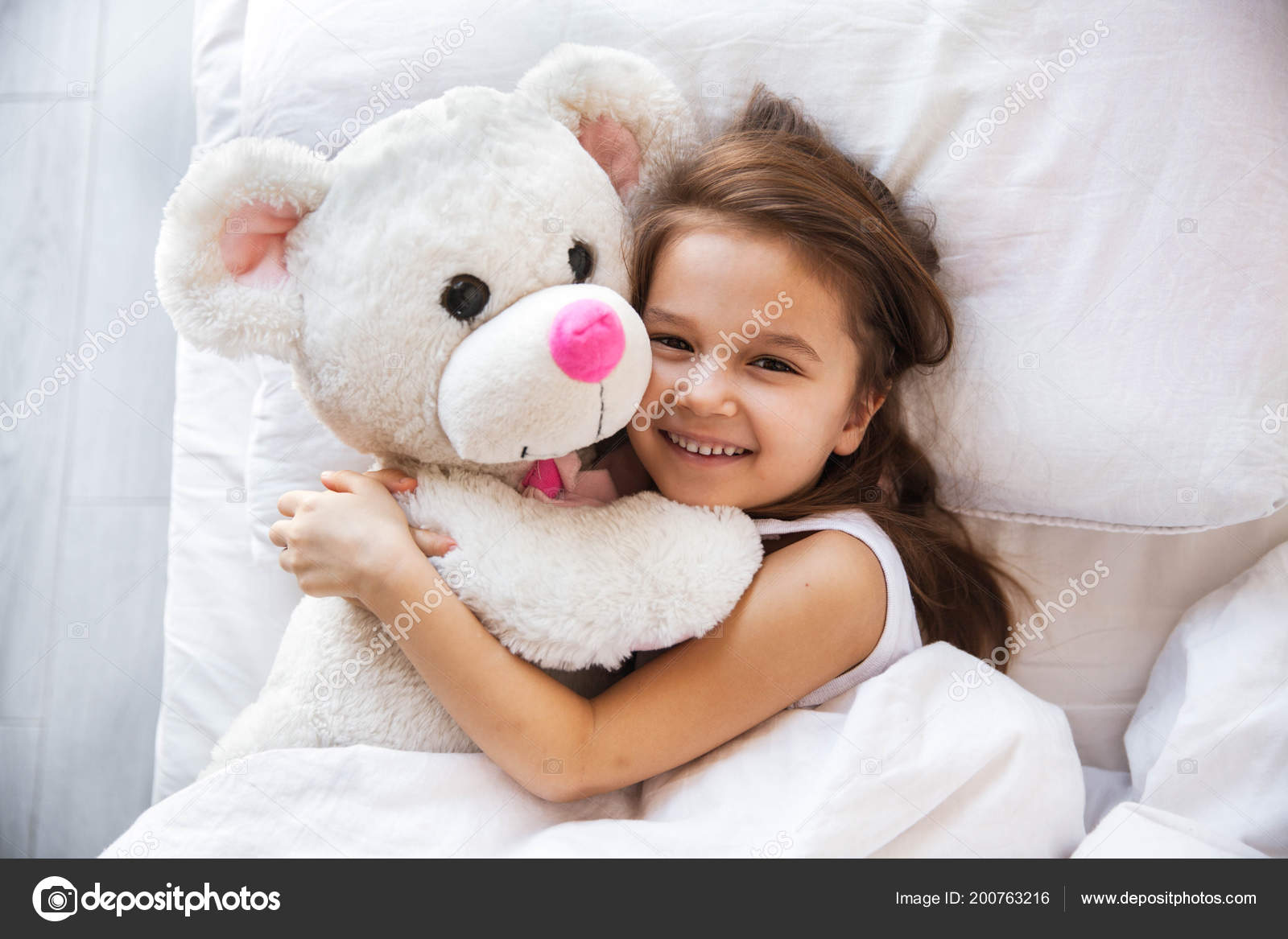 little girl hugging teddy bear