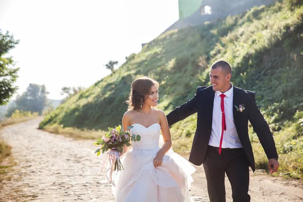 Belo casal jovem. A noiva e o noivo na natureza. Dia do casamento. Roupa de férias — Fotografia de Stock