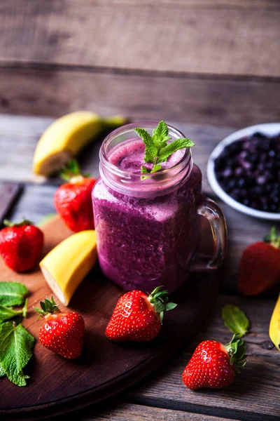 Blueberry smoothie pada latar belakang kayu dengan buah-buahan. Vitamin — Stok Foto