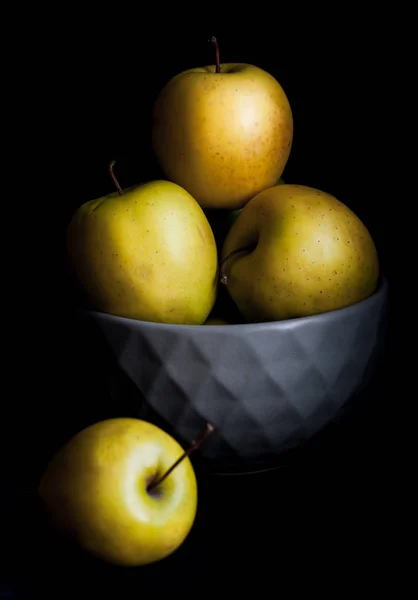 Schale mit gelben Äpfeln vorhanden. auf schwarzem Hintergrund. — Stockfoto