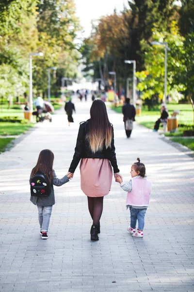 Famille - mère et deux enfants marchant dans la rue — Photo