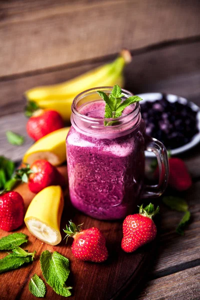 Blueberry smoothie pada latar belakang kayu dengan buah-buahan. Vitamin — Stok Foto