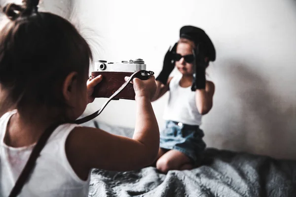 Duas meninas tirando uma foto uma da outra. mulheres pequenas da moda — Fotografia de Stock