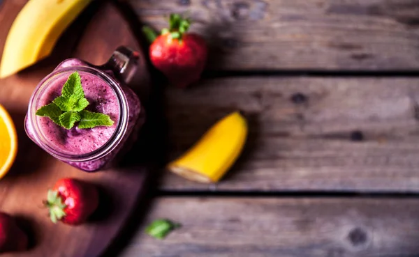Blueberry smoothie pada latar belakang kayu dengan buah-buahan. Vitamin — Stok Foto
