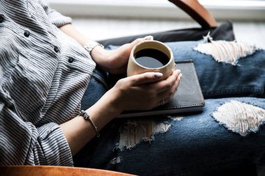 Güzel manikür genç bir kızla bir kitap bir fincan kahve ile tutar. Moda stil