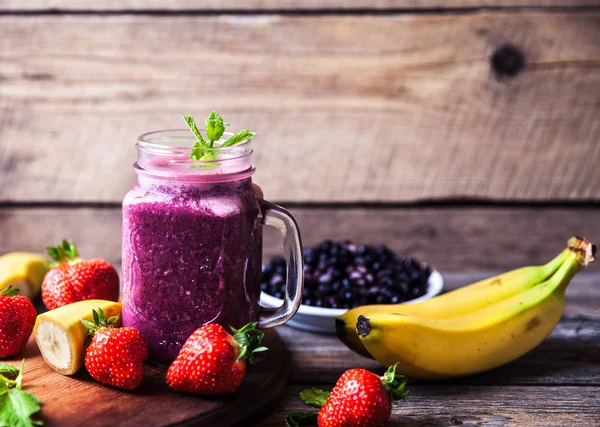 Blueberry smoothies on a wooden background with fruits. Vitamins — Stock Photo, Image