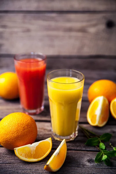 Sok pomarańczowy w szkle z mięty, świeże owoce na drewniane tła — Zdjęcie stockowe