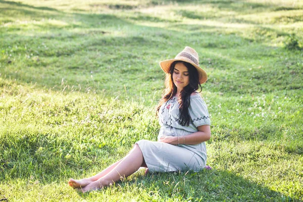 9 maanden zwangere vrouw liggend op de grond en lachend. Wachten voor de baby. Zwangerschap concept. — Stockfoto