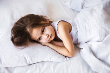 evde yatakta uyuyan sevimli küçük kız