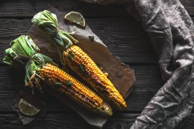 Izgara Mısır soslu, eski ahşap arka planda kişniş. Meksika yemeği. Üst görünüm. Kopya alanı, sağlıklı gıda, sebze