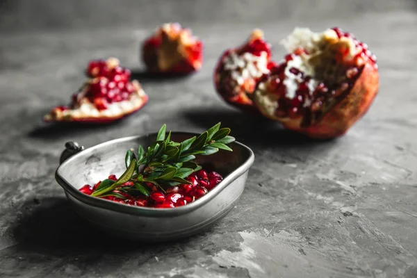 Mat foto av röd mogen granatäpple bitar i skålen på det grå bordet med kopia utrymme. Hälsosam mat, — Stockfoto