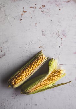 Ham Mısır taze yeşil Cornhusk ile rustik masa antika arka plan üstten görünüm üzerinde aldı