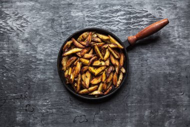 Bir tavada sıcak patates kızartması. Koyu arka plan