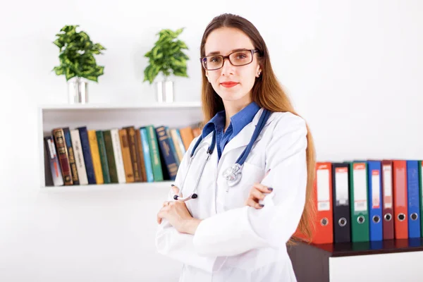 Young woman doctor in white coat standing in doctors office