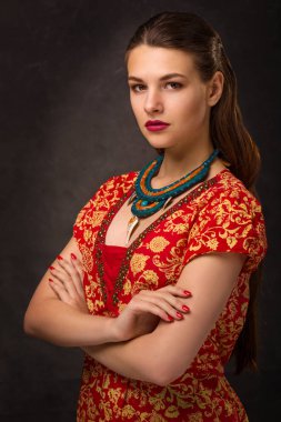 Güzel genç kadın esmer modeli el yapımı aksesuarlar moda takı kolye. Kameraya bakıyor. Moda fotoğraf.