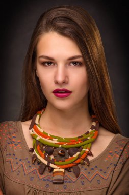 Güzel genç kadın esmer modeli el yapımı aksesuarlar moda takı kolye. Kameraya bakıyor. Moda fotoğraf.