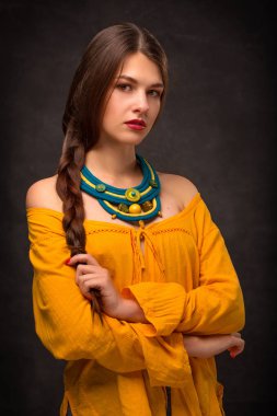 Güzel genç kadın esmer modeli el yapımı aksesuarlar moda takı kolye. Kameraya bakıyor. Moda fotoğraf.