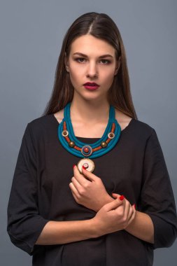 Güzel genç kadın esmer modeli el yapımı aksesuarlar moda takı kolye. Kameraya bakıyor. Moda fotoğraf.