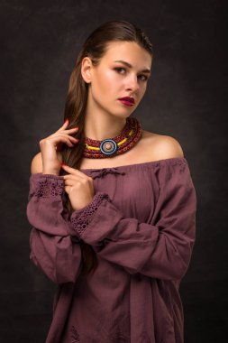 Güzel genç kadın esmer modeli el yapımı aksesuarlar moda takı kolye. Kameraya bakıyor. Moda fotoğraf.